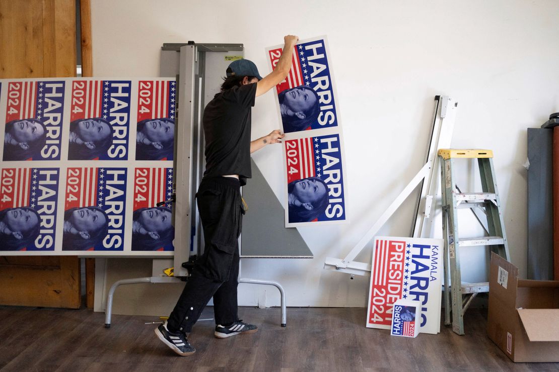 A print production specialist at a print shop in Tucson, Arizona, cuts a run of Harris yard signs on July 25, 2024.