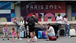 Travellers from Sydney, Australia, wait outside the Gare Montparnasse train station as they try to search for other trains after their trip was affected when vandals targeted France's high-speed train network with a series of coordinated actions that brought major disruption, ahead of the Paris 2024 Olympics opening ceremony, in Paris, France, July 26, 2024. REUTERS/Maye-E Wong     TPX IMAGES OF THE DAY