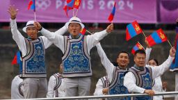 Team Mongolia waves from a boat in the floating parade on the river Seine during the Paris 2024 Olympics opening ceremony on July 26, 2024.