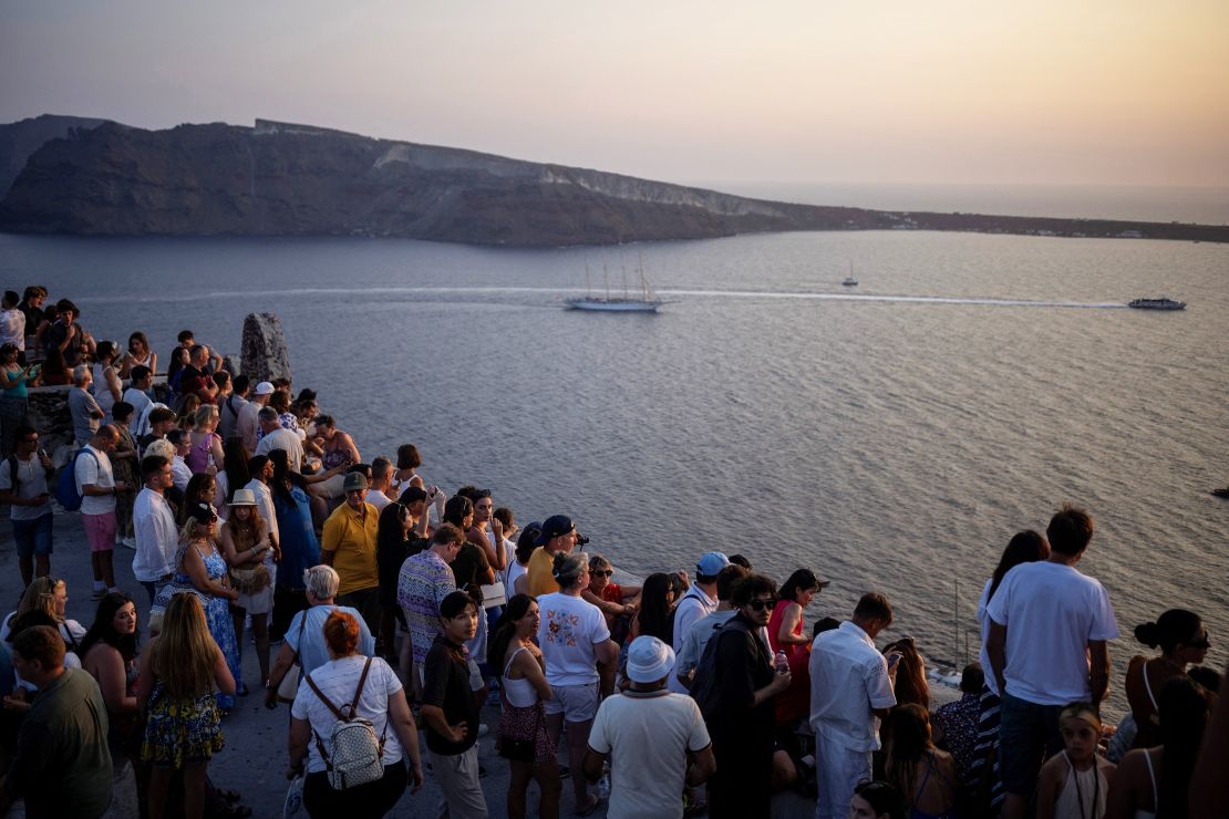 Tourists view Santorini’s famed sunset from the Castle of Oia on the popular island in Greece on July 25, 2024.