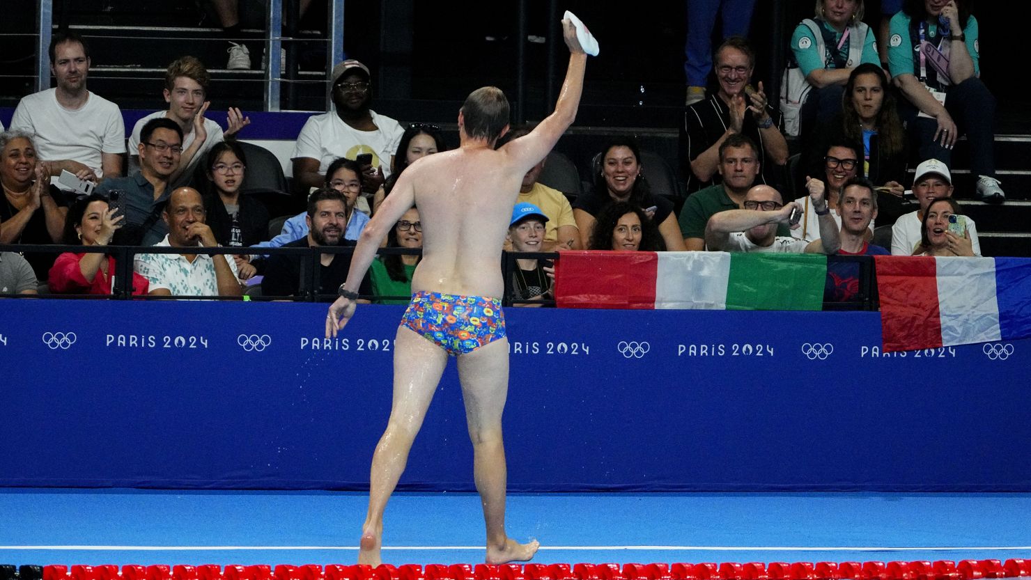 The crowd cheers for a man who retrieved Emma Weber’s (USA) swim cap from the pool during the women’s 100-meter breaststroke prelim heats at Paris La Défense Arena.