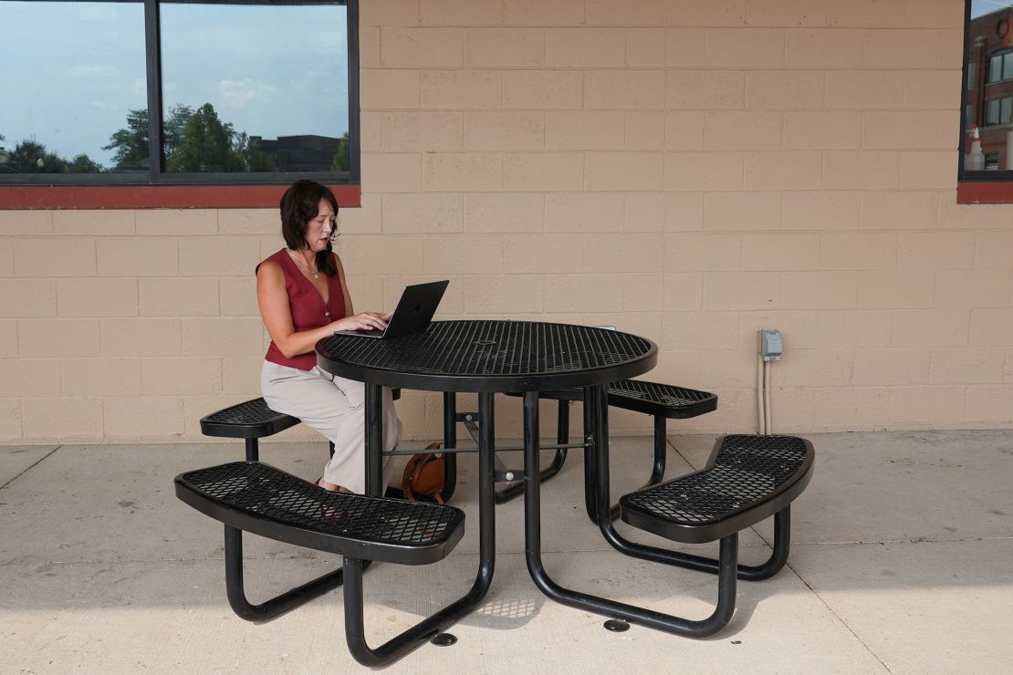 Lyz Lenz, co-chair of the Iowa Abortion Access Fund, types on her laptop outside a cafe in Cedar Rapids, Iowa, on July 28, 2024.