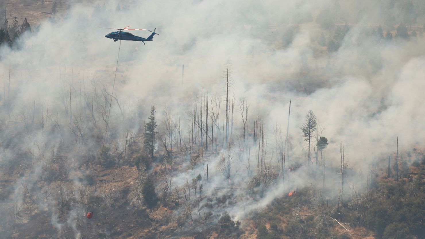 A helicopter drops water over hotspots of the Park Fire, near Butte Meadows, California, on July 29.