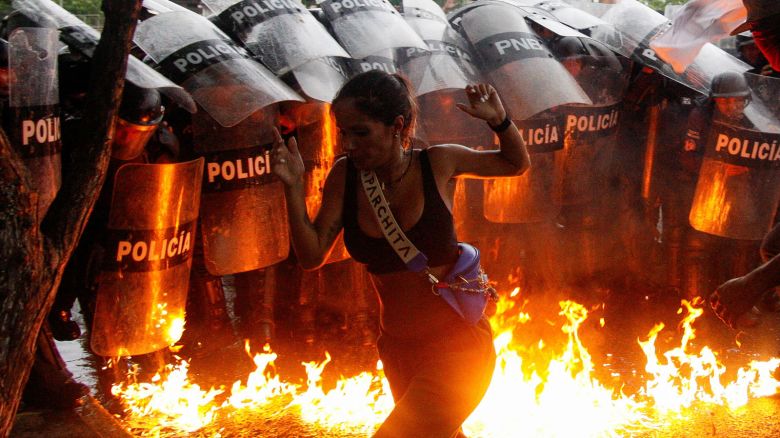 A demonstrator reacts when Molotov cocktails hit the ground in front of security forces during protests against election results after Venezuela's President Nicolas Maduro and his opposition rival Edmundo Gonzalez claimed victory in Sunday's presidential election, in Puerto La Cruz, Venezuela July 29, 2024. REUTERS/Samir Aponte