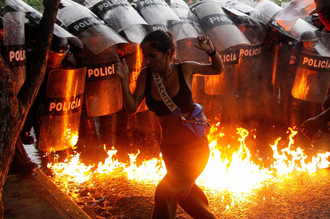 A demonstrator reacts as Molotov cocktails hit the ground in front of security forces during protests in Puerto La Cruz, Venezuela, on July 29, 2024.