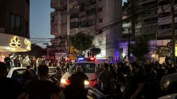 People gather near a site hit by what security sources said was a strike on the southern suburbs of Beirut, Lebanon, on July 30, 2024.