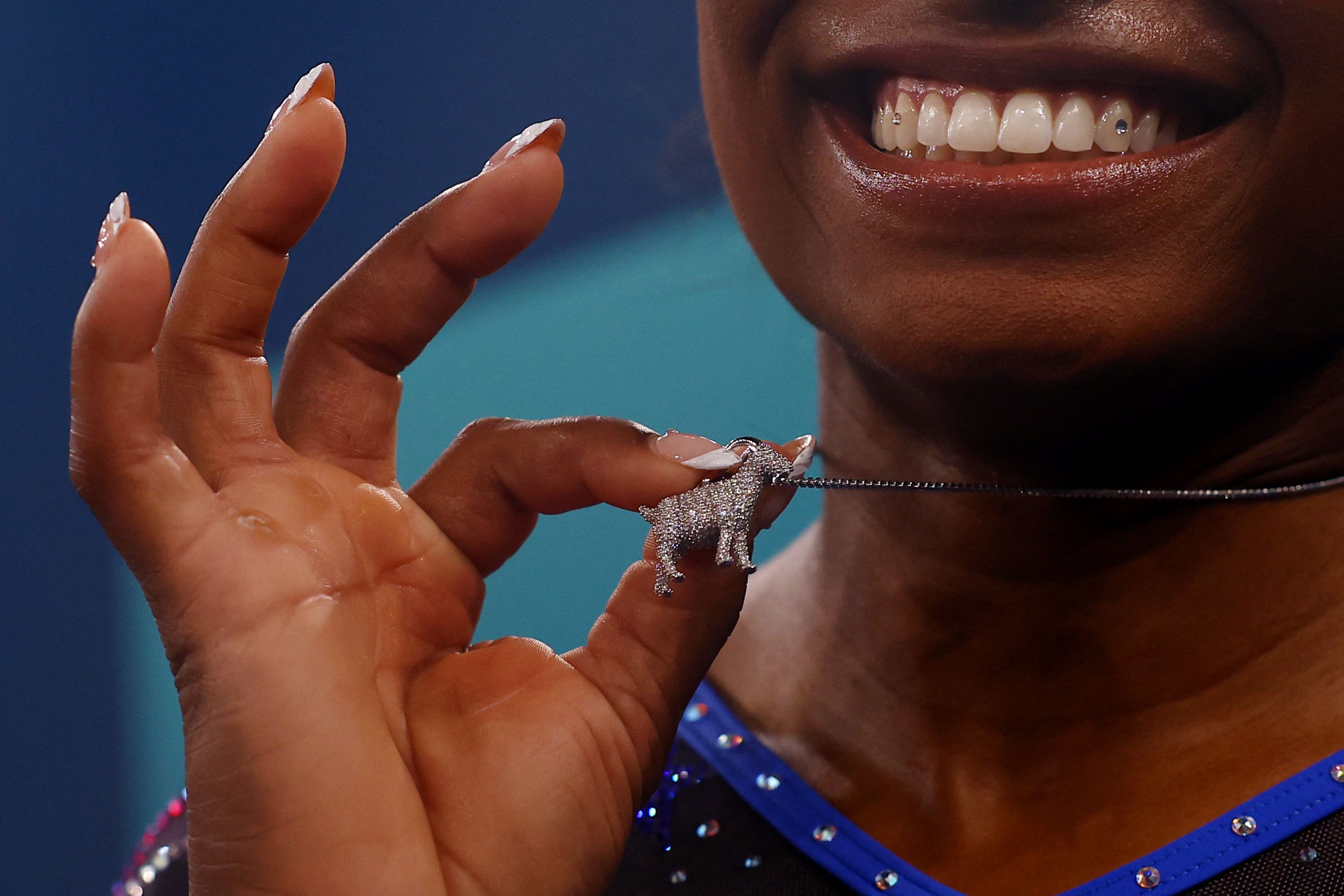 Biles shows off a goat necklace after winning gold on Thursday. Many consider Biles to be the GOAT: greatest of all time.