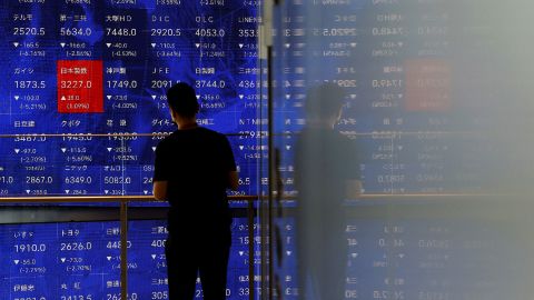 A man stands next to an electronic stock quotation board inside a building in Tokyo, Japan August 2, 2024. REUTERS/Issei Kato