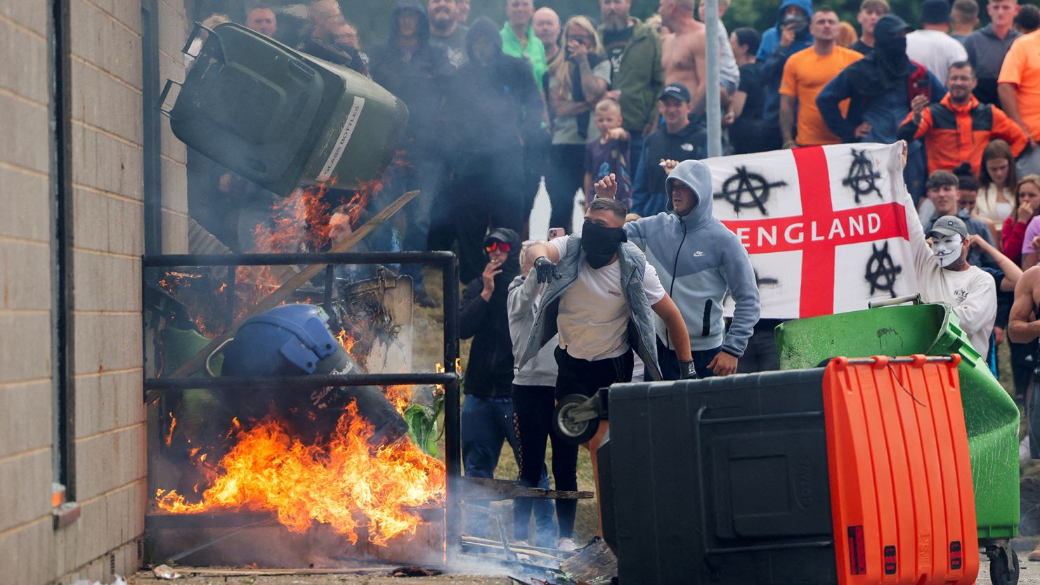 Rioters throw a garbage bin on fire outside a hotel in Rotherham, Britain, on August 4, 2024.