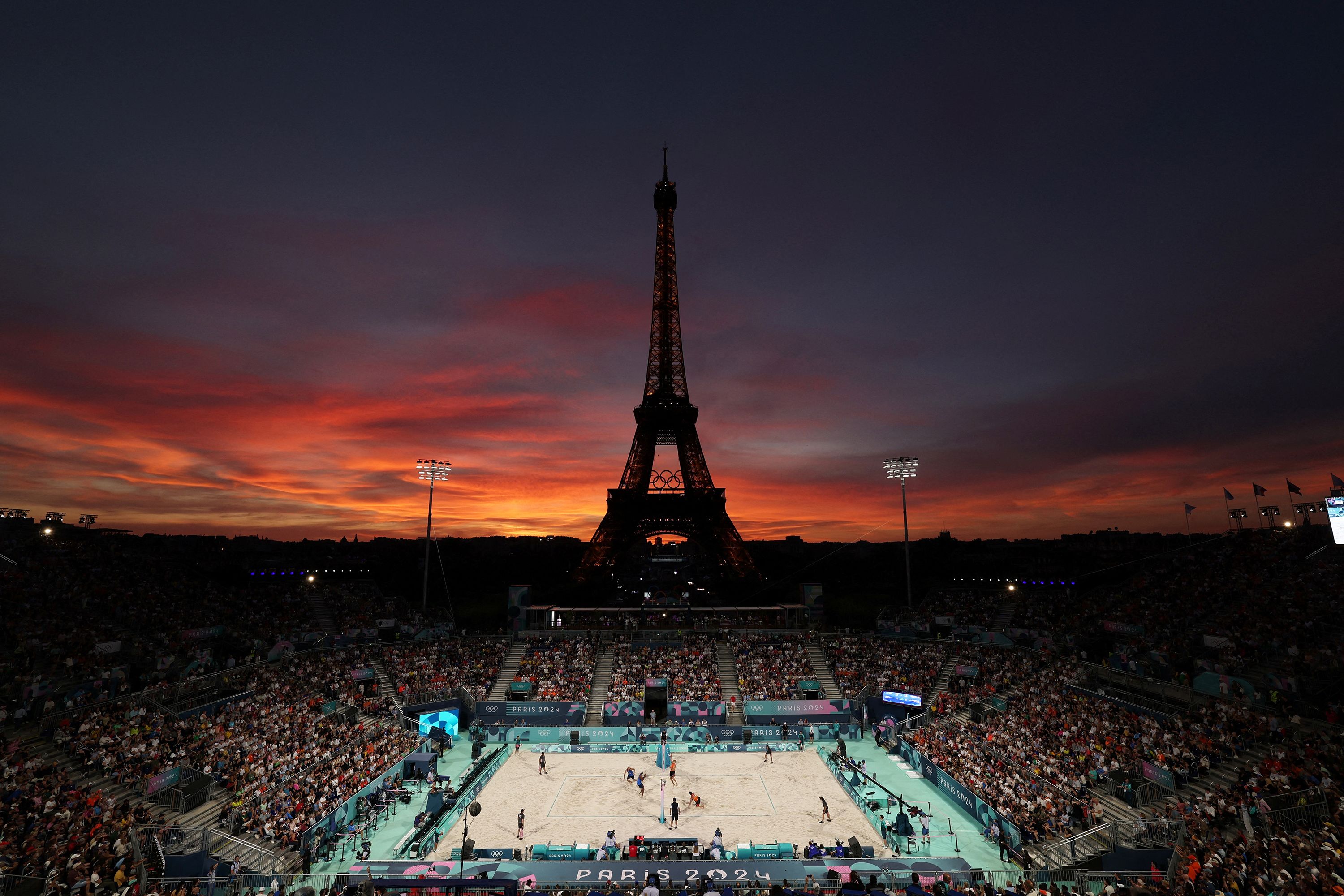 The sun sets behind the Eiffel Tower during a beach volleyball match on August 4.