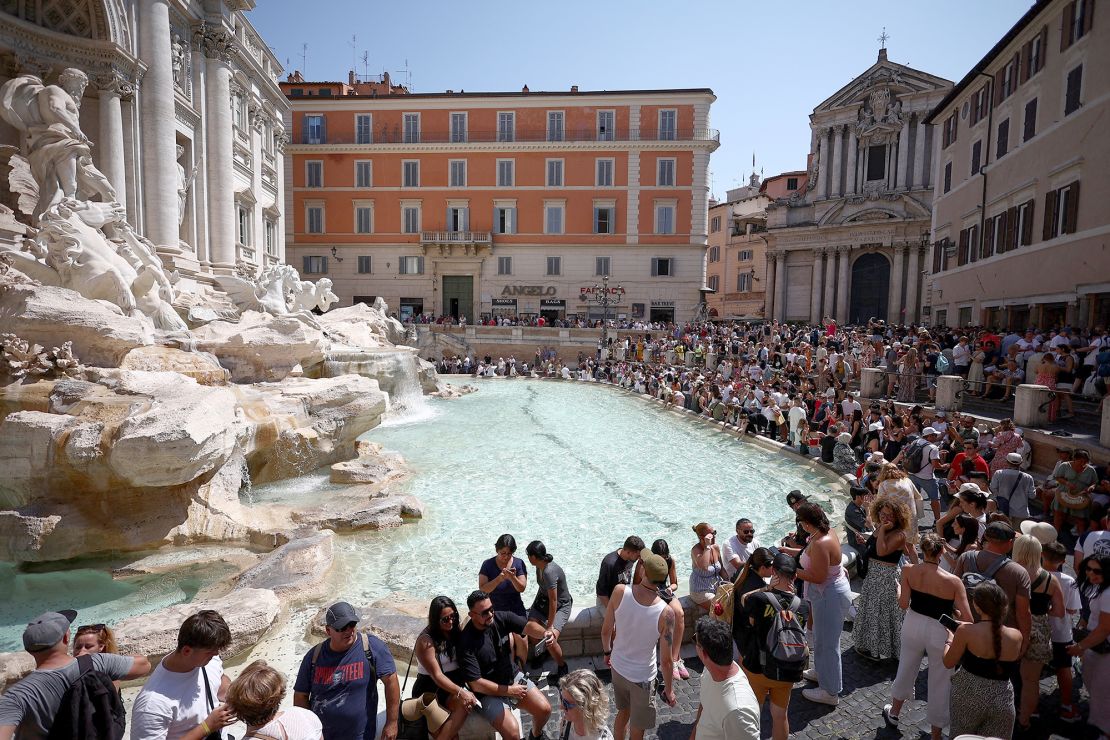 Crowds of tourists visit the Trevi Fountain in August.