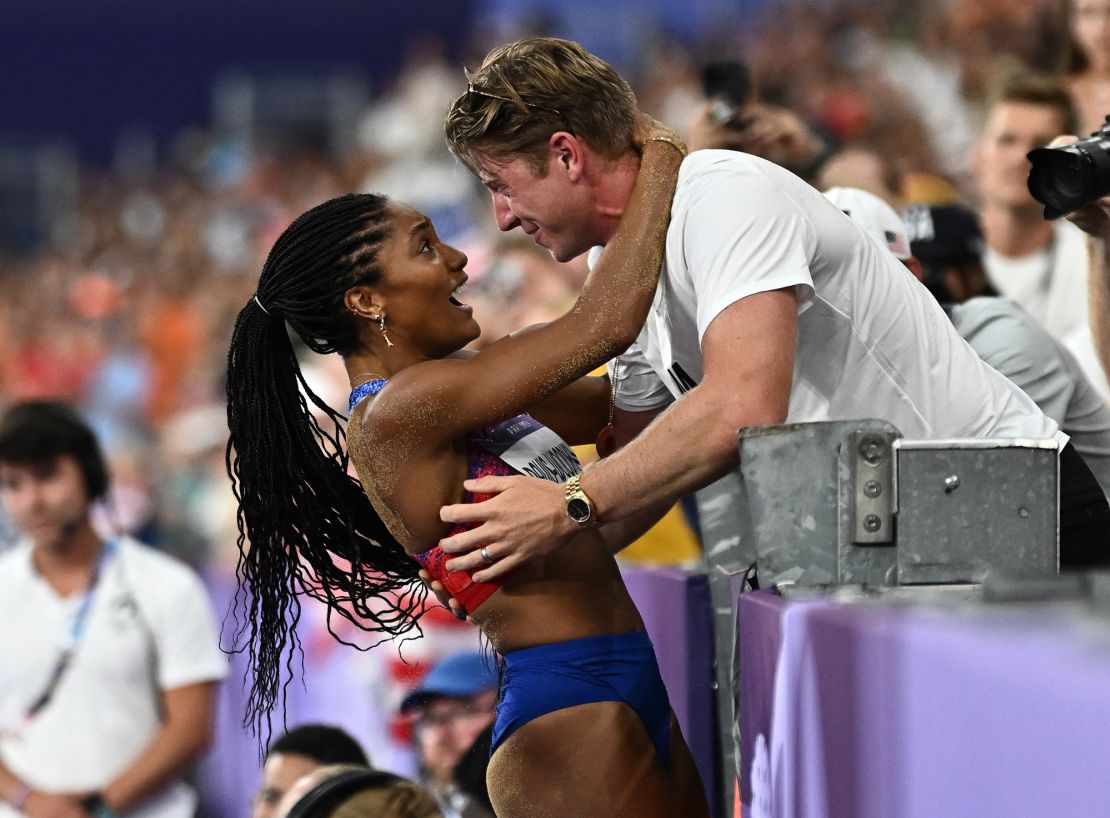 Tara Davis-Woodhall celebrates her gold win with her husband Hunter Woodhall.