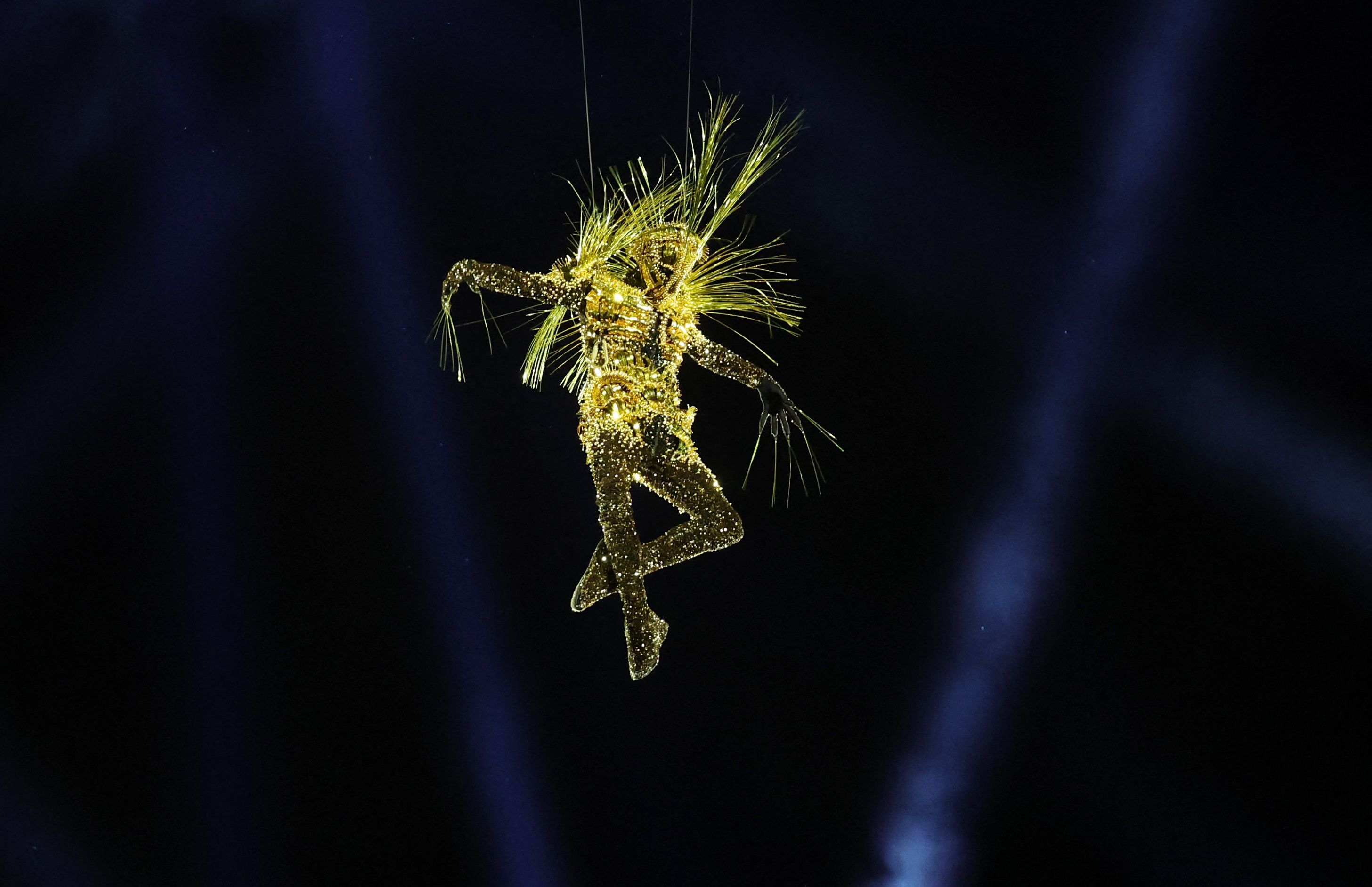 The Golden Voyager floats onto the stage from the roof of the Stade de France.