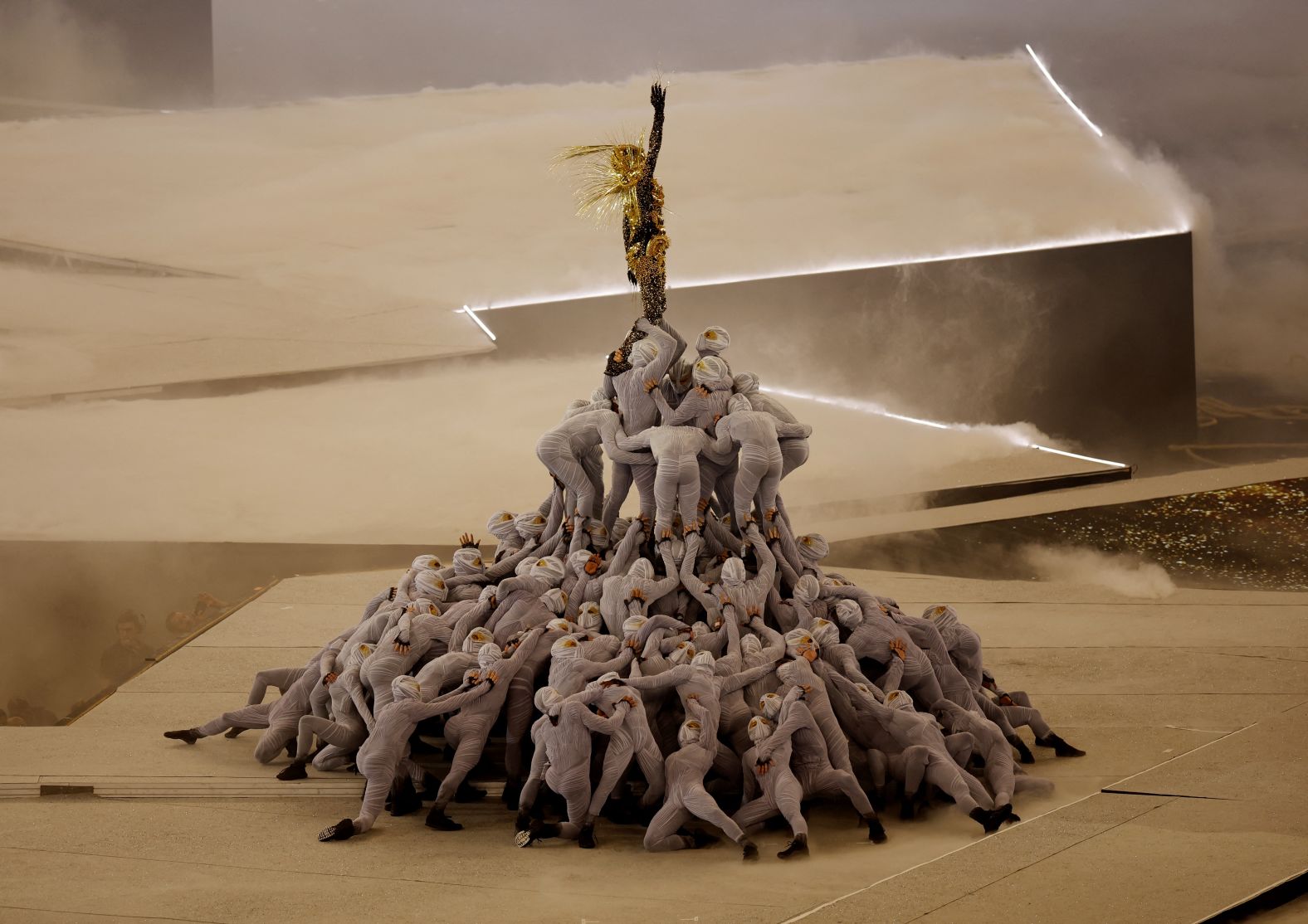 A Golden Voyager, inspired by references from French history, stands atop a pile of masked dancers as the last Olympic ring is raised above the stage.