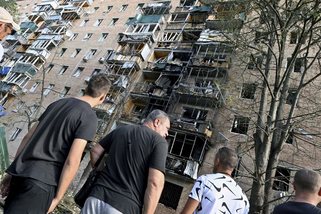 People gather in the courtyard of a building which was hit by debris from a destroyed Ukrainian missile in Kursk on August 11.