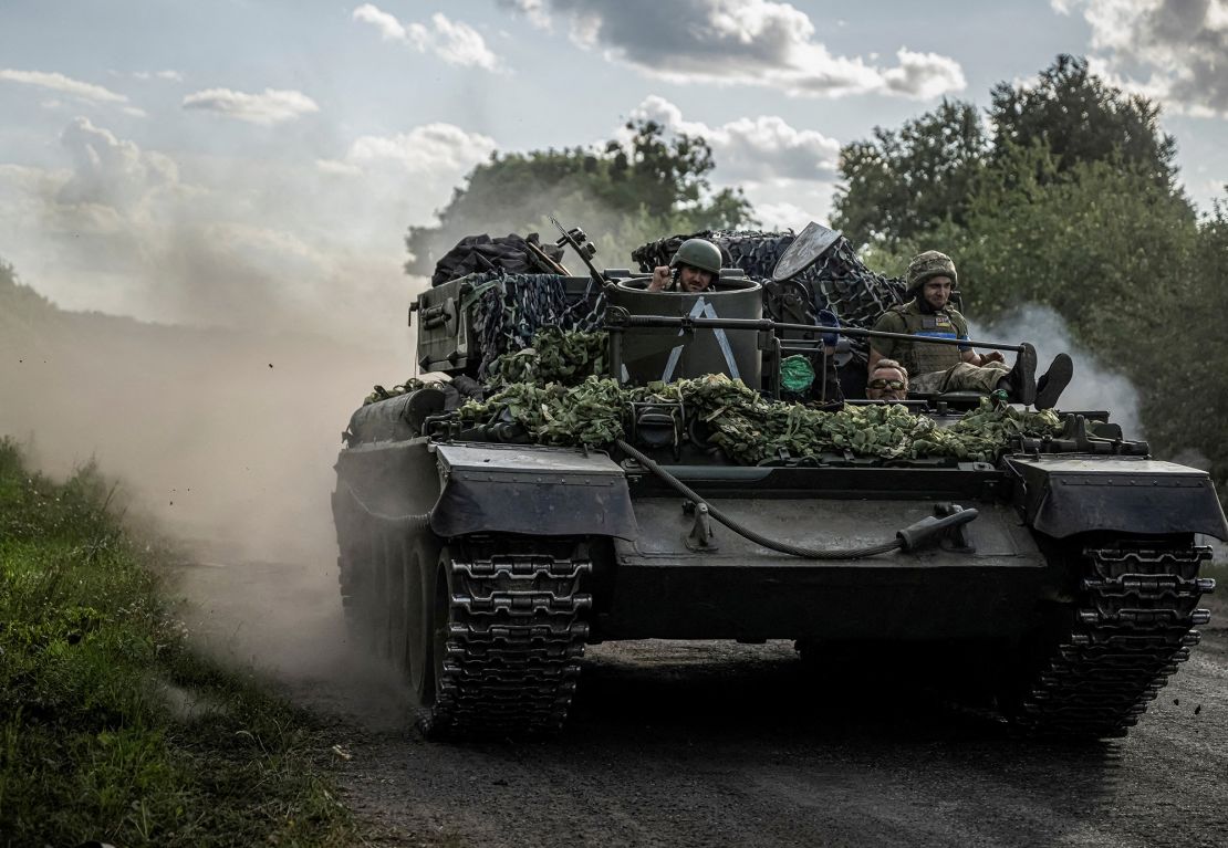 Ukrainian servicemen ride a military vehicle near the Russian border in Ukraine's Sumy region on August 11, 2024.