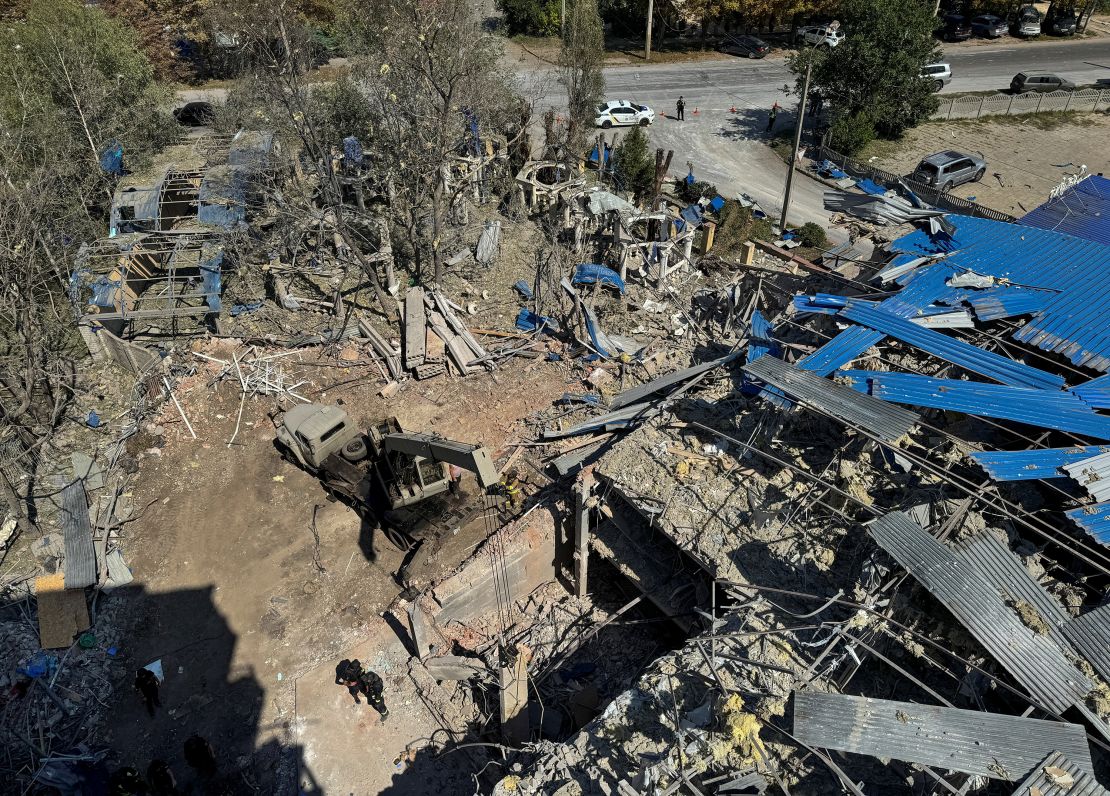 Rescue workers stand at the site where the hotel was hit.