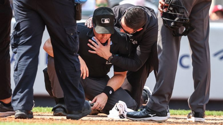 Aug 25, 2024; Bronx, New York, USA;  Home plate umpire Nick Mahrley (48) is checked on after getting hit by a broken bat in the fifth inning during the game between Colorado Rockies and New York Yankees at Yankee Stadium. Mandatory Credit: Wendell Cruz-USA TODAY Sports