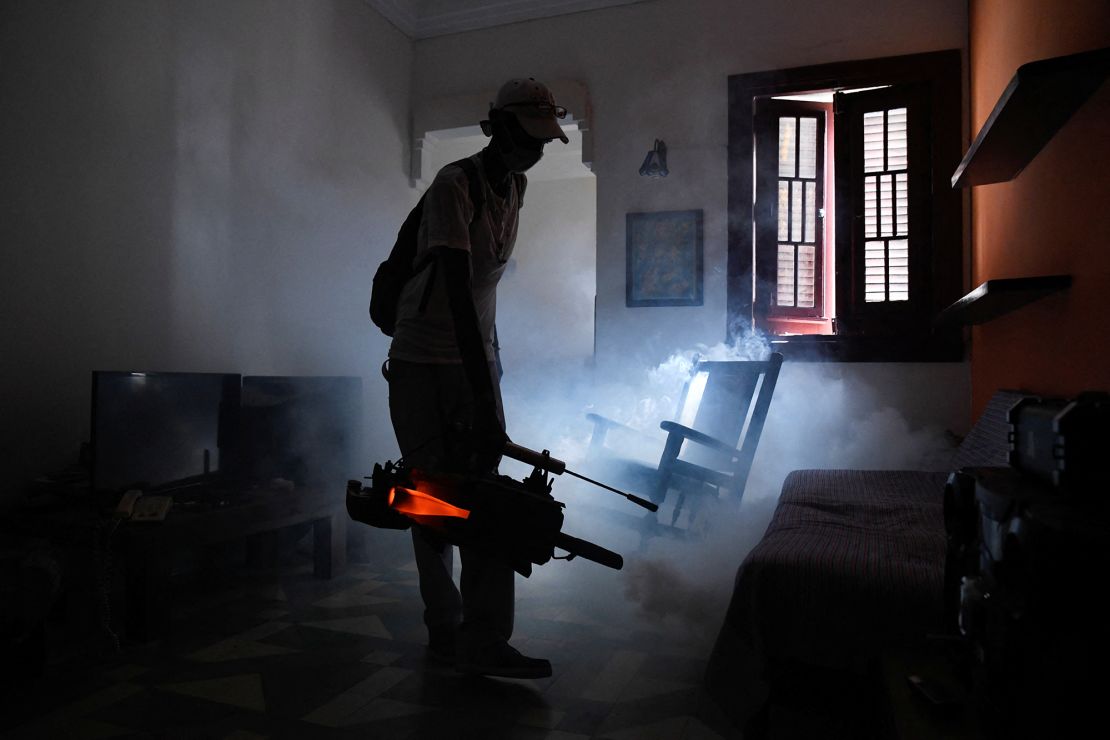 A health worker fumigates an apartment in Cuba as health authorities launch small-scale fumigation efforts in a bid to fight the spread of the oropouche virus.