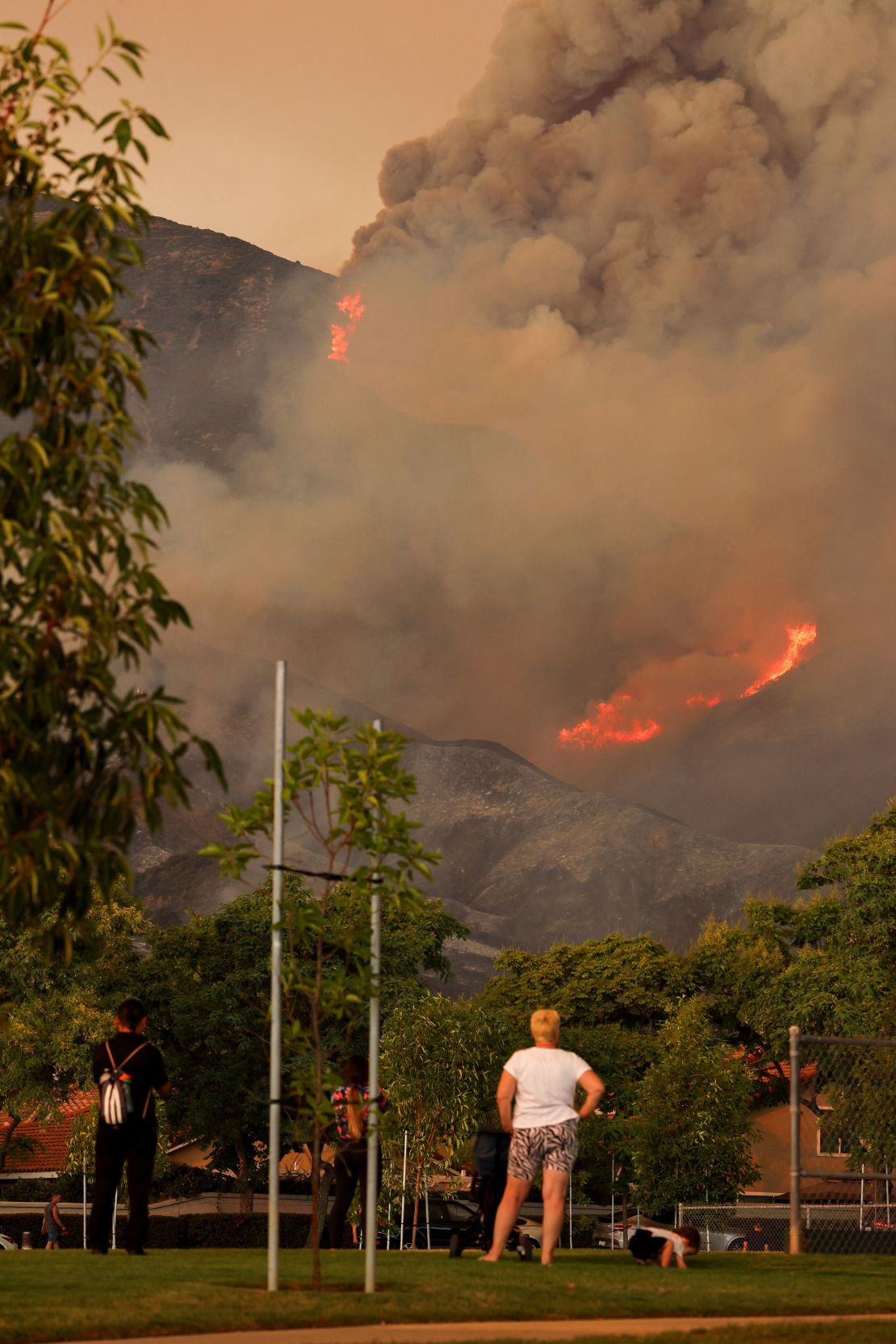 People look on, as the Airport Fire burns in the hills of Orange County, California, on September 9.