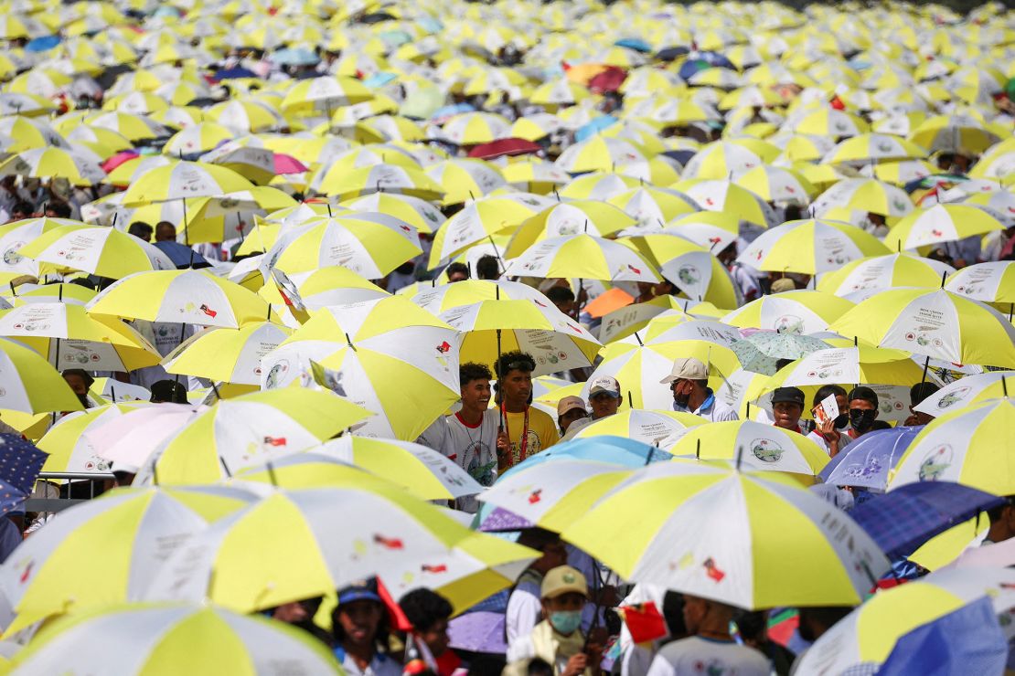 Crowds waiting for Pope Francis sheltering from the sun.