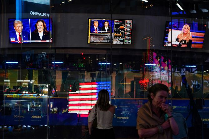 Screens show the debate outside the Nasdaq MarketSite in New York.