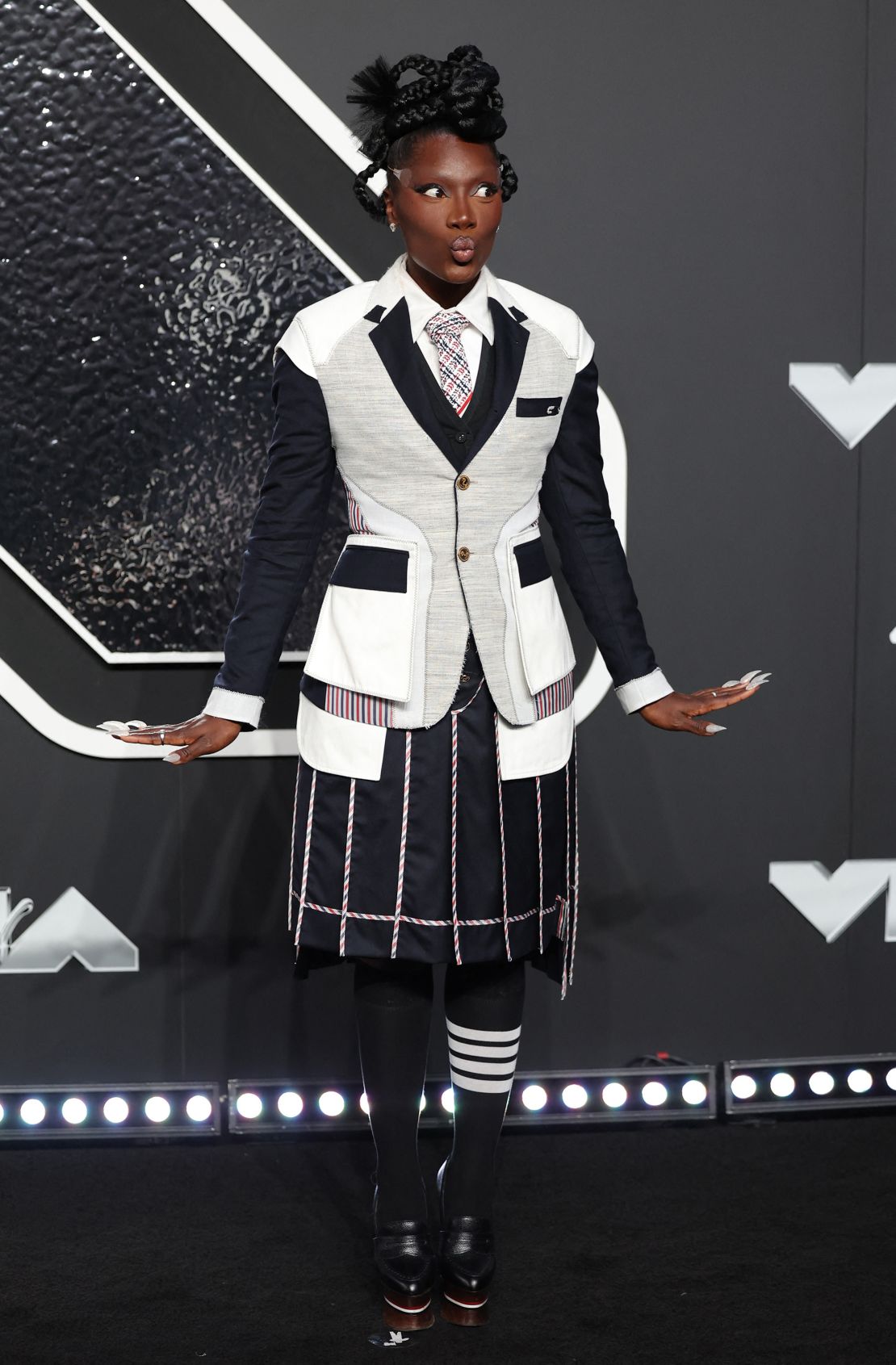 Doechii in a Thom Browne outfit bearing the designer’s signature four-stripe motif.