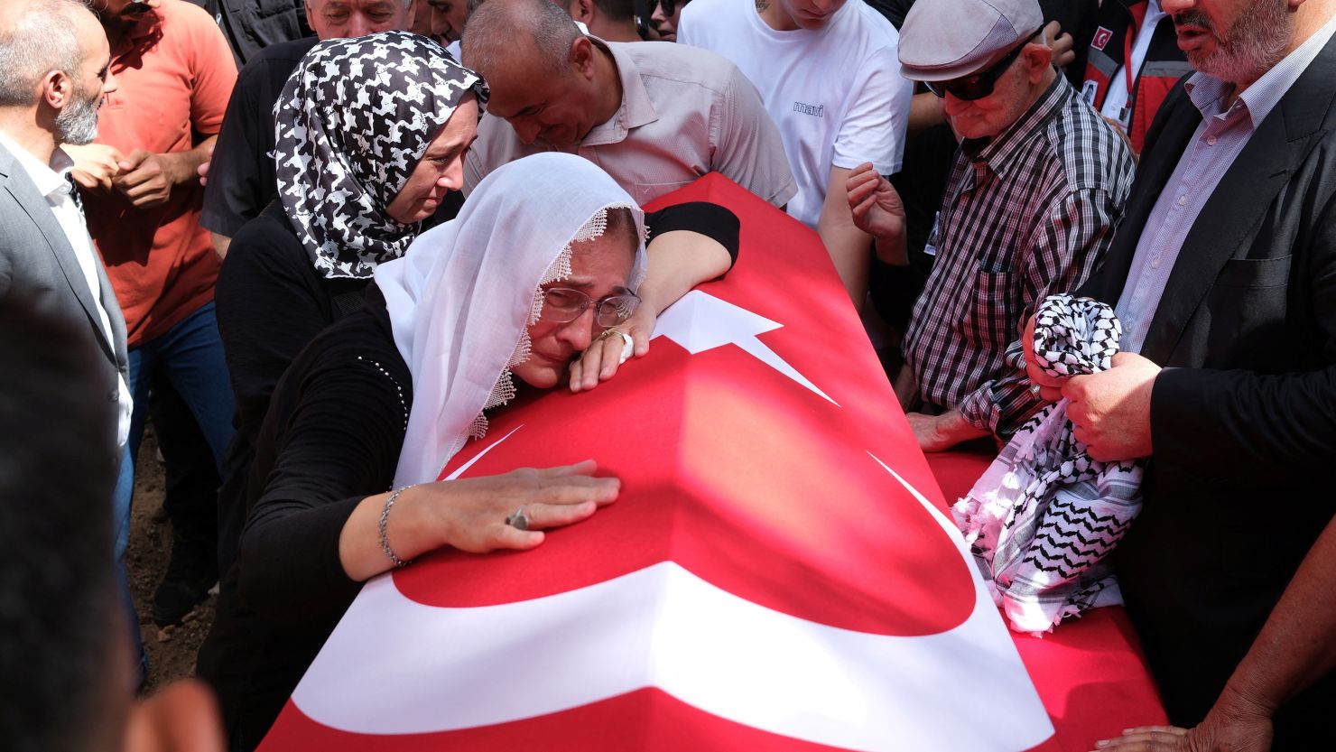 A relative of Aysenur Ezgi Eygi, a Turkish-American activist killed in the Israeli-occupied West Bank, mourns over her Turkish flag-draped coffin during the funeral ceremony at a cemetery in Didim.