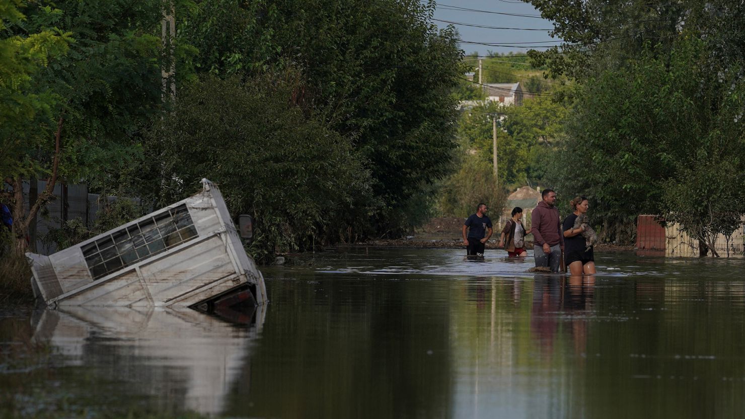 People walk on a flooded road after heavy rain triggered flooding in Cuza Voda, Galati county, Romania, September 15, 2024.