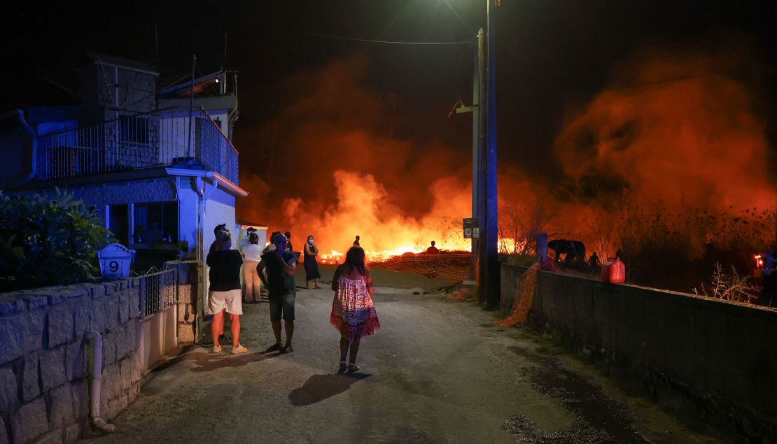 Mensen kijken maandag naar een enorme brand in Canas de Sinhorim, Portugal.