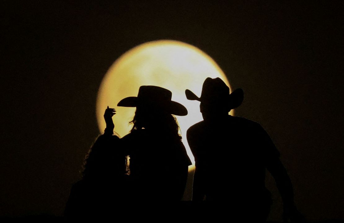 People look at the full moon on Tuesday at the Samalayuca Dunes on the outskirts of Ciudad Juarez, Mexico.