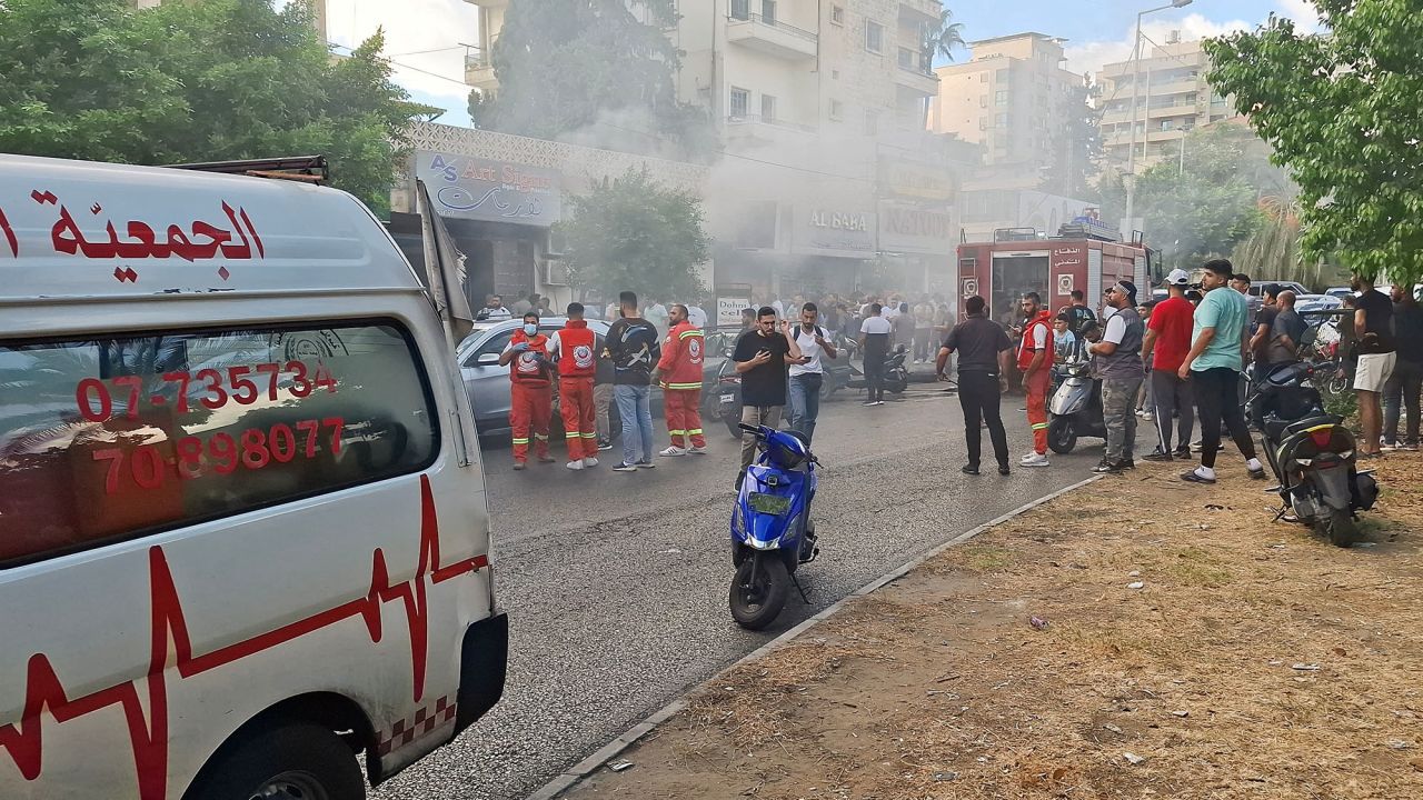 Smoke rises from a mobile shop as civil defence members gather in Sidon, Lebanon September 18, 2024. REUTERS/Hassan Hankir 