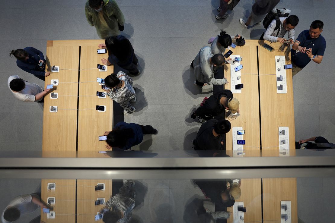 Staff members attend to customers as the new iPhone 16 series smartphones go on sale at an Apple store in Beijing, China, on September 20, 2024.