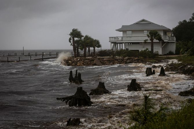 Sóng đánh vào kè chắn sóng của một ngôi nhà vào thứ năm tại Eastpoint, Florida.