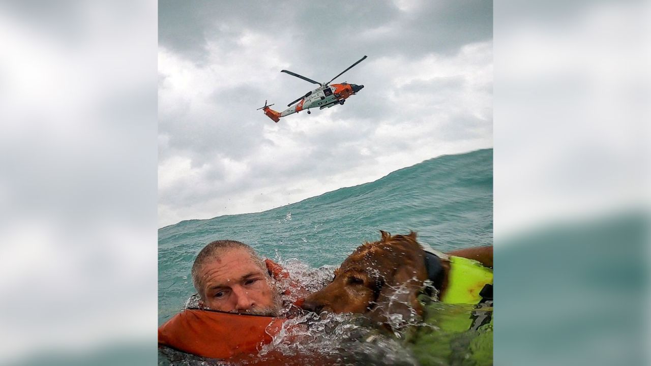 In this screengrab taken from a <a  target="_blank">United States Coast Guard body cam</a>, a man and his dog are seen being rescued after his sailboat became disabled and started taking on water off Sanibel Island, Florida, on Thursday, September 26.