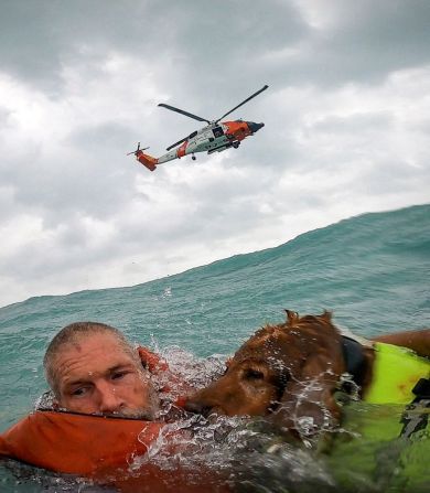 In this screengrab taken from a <a href="https://x.com/USCGSoutheast/status/1839595599861027186" target="_blank">United States Coast Guard body cam</a>, a man and his dog are seen being rescued after his sailboat became disabled and started taking on water off Sanibel Island, Florida, on September 26.