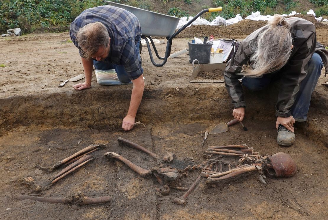 Archaeologists excavate skeletons in a pit at the Viking-age burial site in the village of Åsum, Denmark, on September 25.