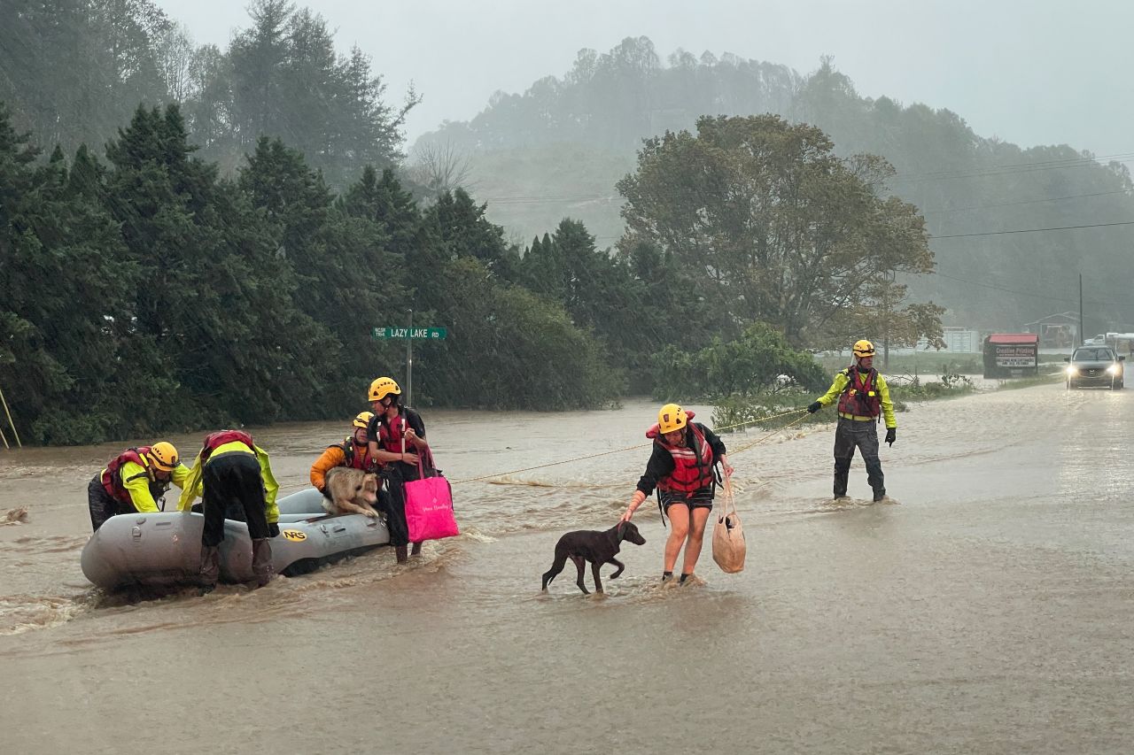 People lead their pets to safety after they were rescued from severe flooding in Boone, North Carolina, on Friday.