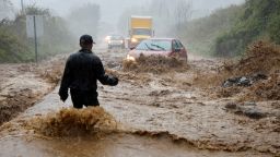 A local resident walks out into fast-flowing waters to assist a stranded driver in a stretch of flooded road as Tropical Storm Helene strikes, on the outskirts of Boone, North Carolina, U.S. September 27, 2024.  REUTERS/Jonathan Drake