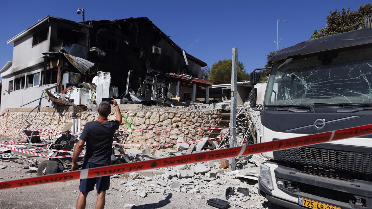 A man takes a picture of a house damaged following a rocket attack from Lebanon, in Safed, northern Israel, on September 28, 2024.