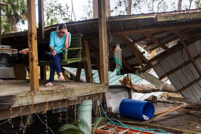 Elmira Glover ngồi trên hiên nhà sau khi nhìn vào bên trong ngôi nhà bị ngập hoàn toàn của mình ở Steinhatchee, Florida, vào thứ Bảy.