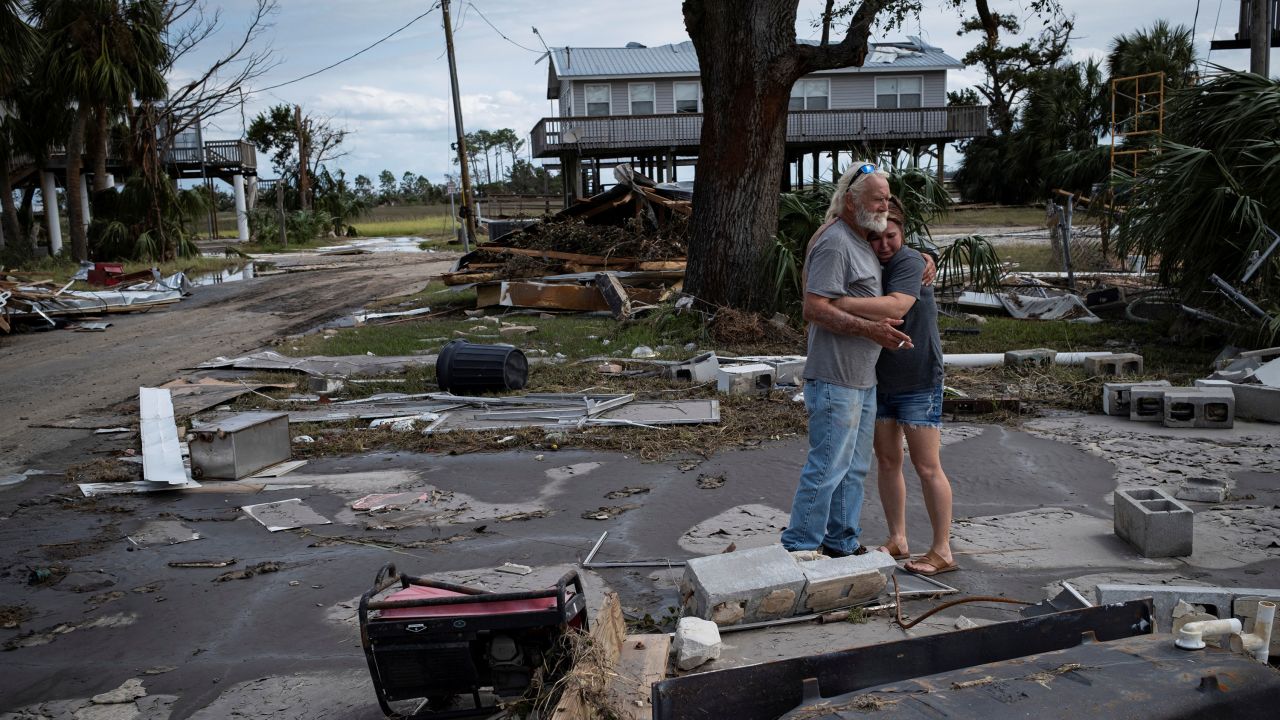 A man embraces his daughter-in-law among the debris of his destroyed home in Horseshoe Beach, Florida, on Saturday.