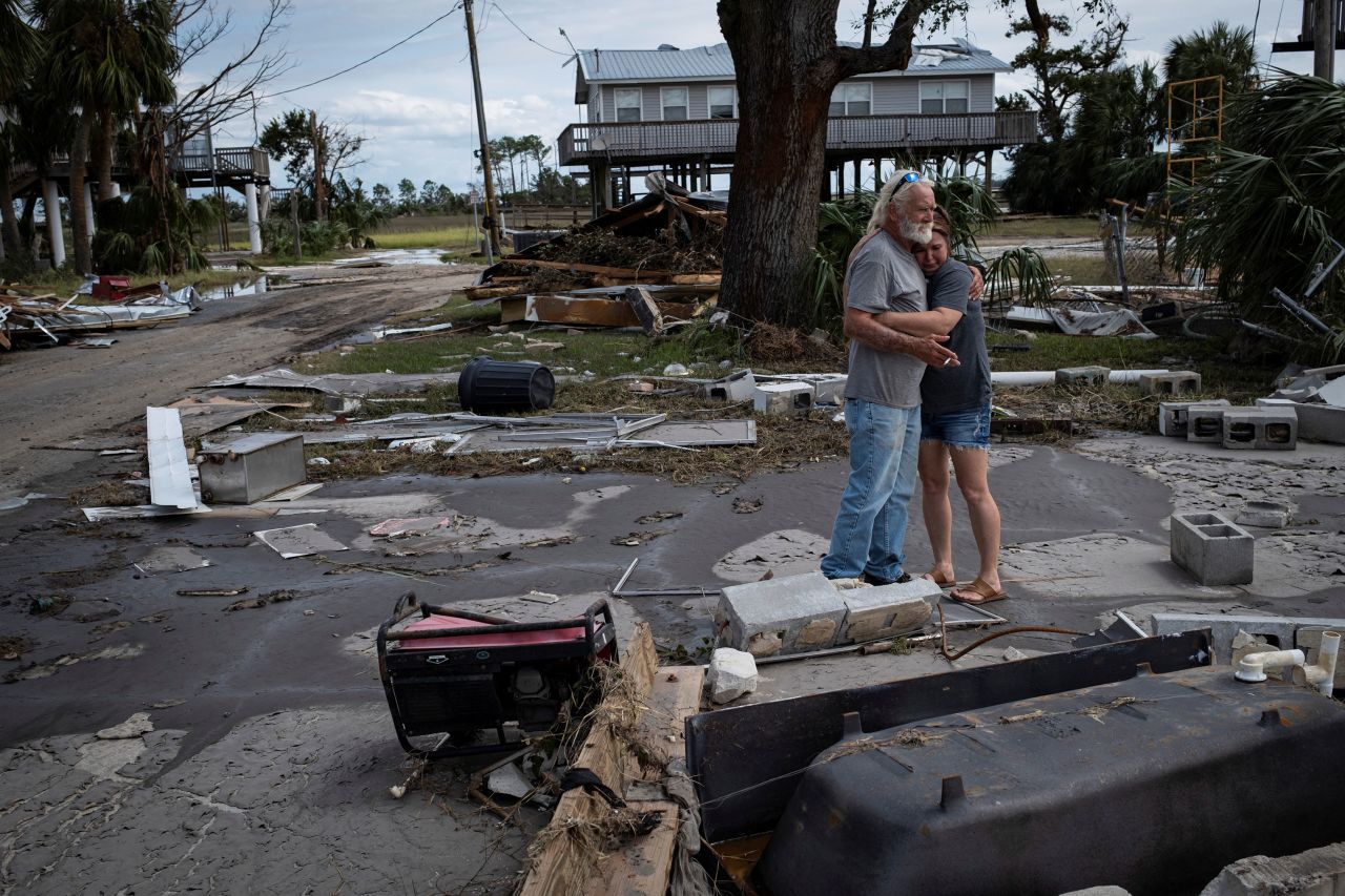 A man embraces his daughter-in-law among the debris of his destroyed home in Horseshoe Beach, Florida, on Saturday.