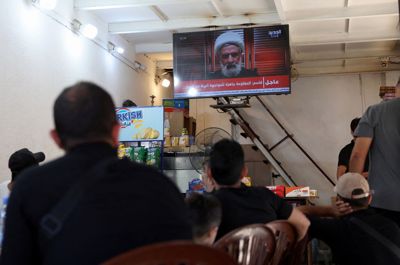 People watch Hezbollah deputy leader Sheikh Naim Qassem delivering a televised address, as they sit at a cafe in Beirut, Lebanon, on September 30.