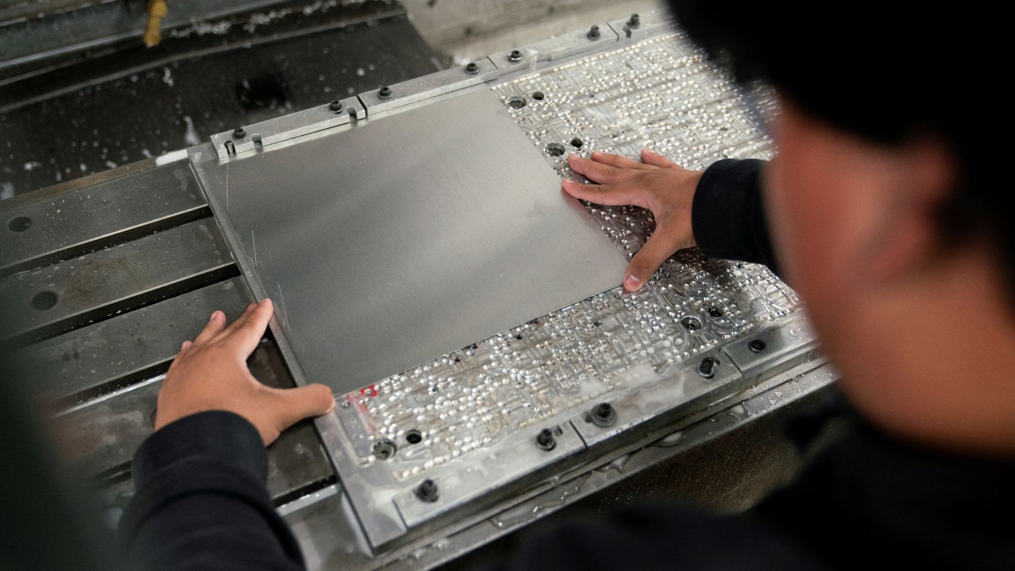 A worker places metal in a milling machine while producing parts for a Boeing 777 jetliner at Pathfinder Manufacturing, near Boeing's Everett widebody jet plant, at a factory in Everett, Washington, on September 25, 2024.