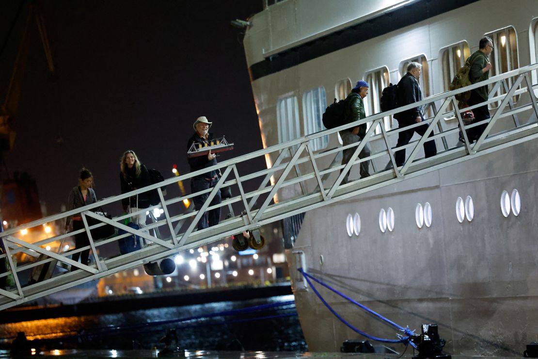 Andy Garrison, 75, carries a model of the Titanic as he boards the Villa Vie Odyssey cruise ship on September 30.