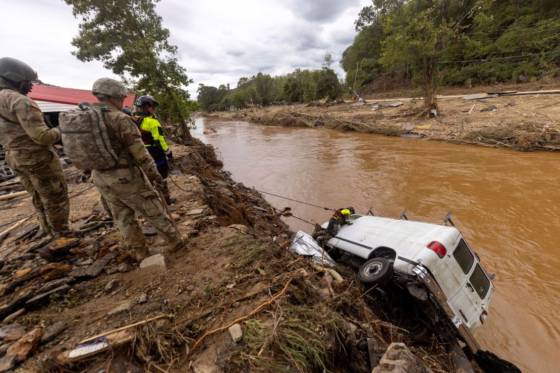 A search and rescue team on Sunday examines a van swept into the river in Swannanoa, North Carolina.