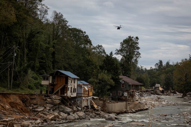 A helicopter flies near damaged buildings in Bat Cave, North Carolina, on Monday.