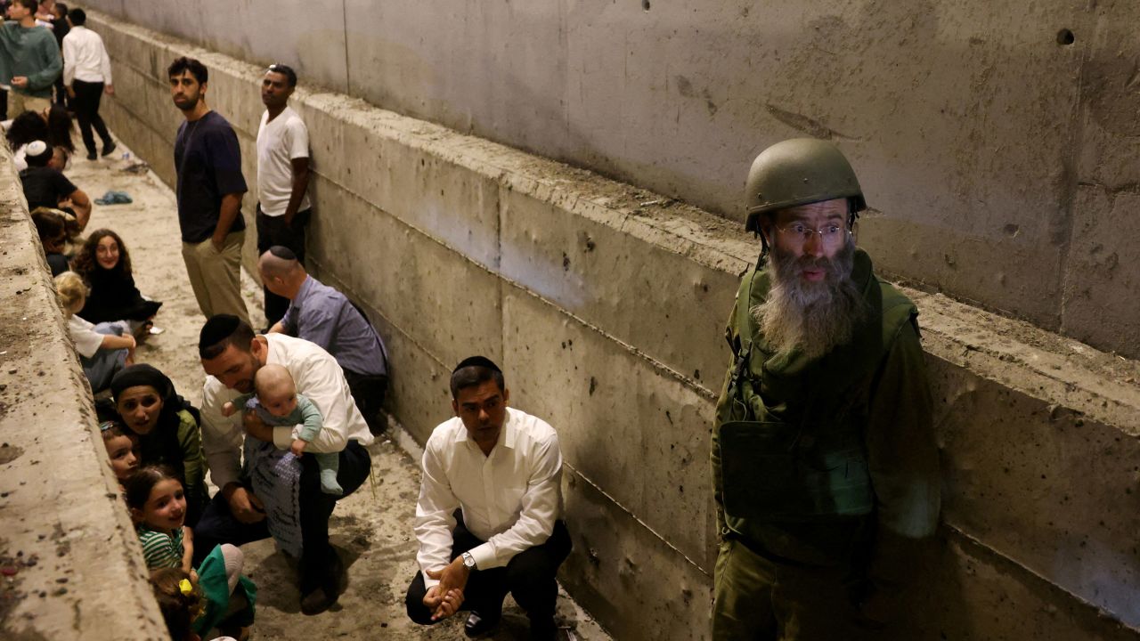 People take shelter during an air raid siren after Iran fired a salvo of ballistic missiles at Israel on October 1.