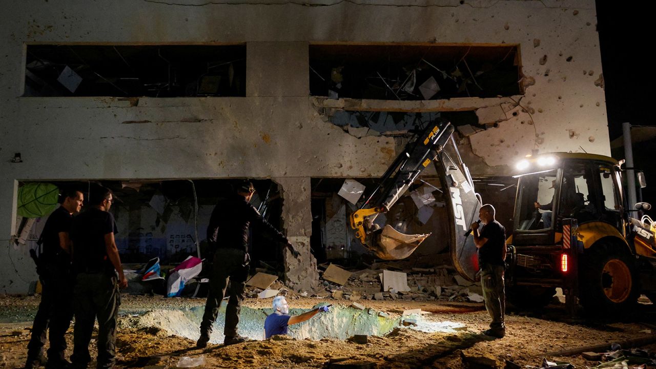 Israeli rescue force members inspect the site where a missile fired from Iran towards Israel hit a school building, in central Israel, on October 1, 2024.